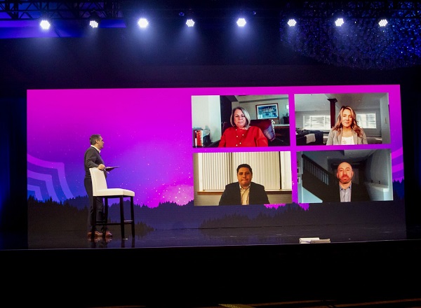 Three office workers are interacting with their colleagues via online in a hybrid setup.